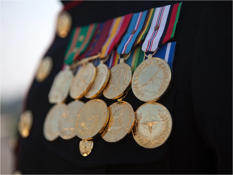 GettyImages-453156557 A soldier's uniform adorned with multiple service medals and ribbons, showcasing achievements and military honors.